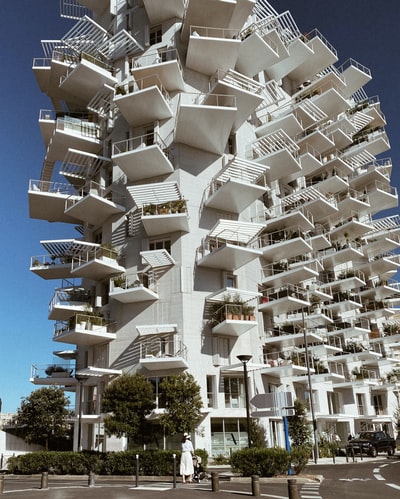 白天绿树旁的白色混凝土建筑